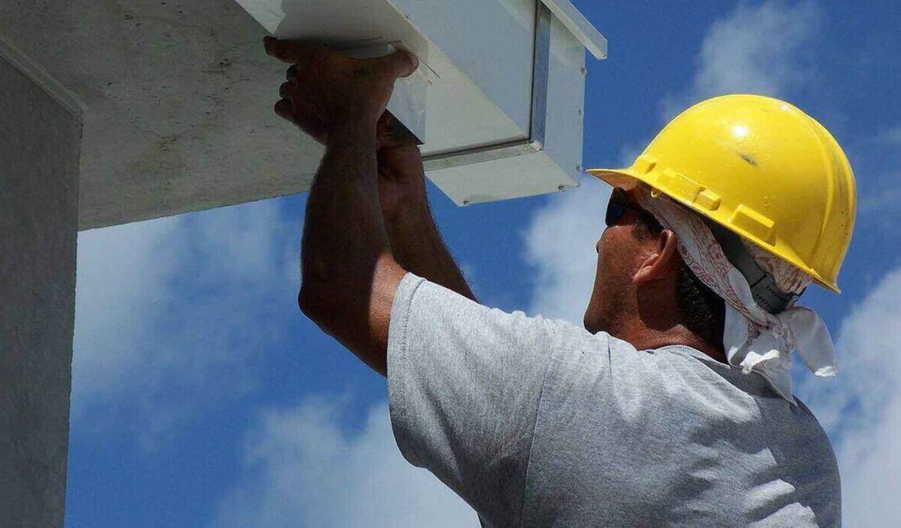 Westcal Property Management's vendors are highly trusted and quality professionals, like this maintenance person fixing a rain gutter.